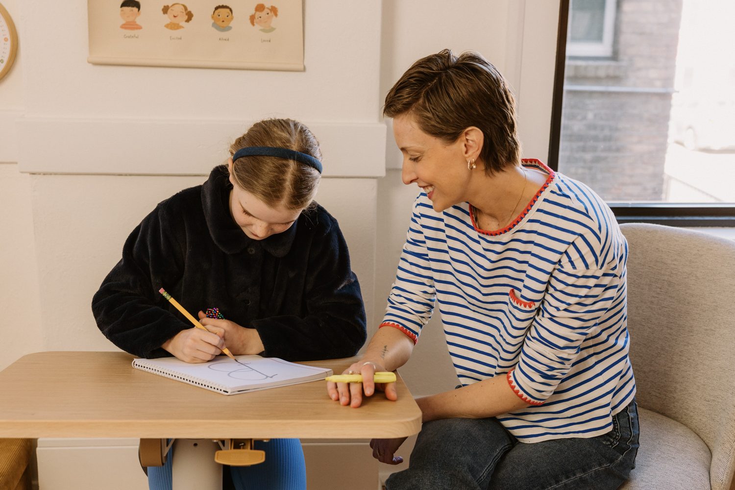 Erin working side by side with a student at a small table